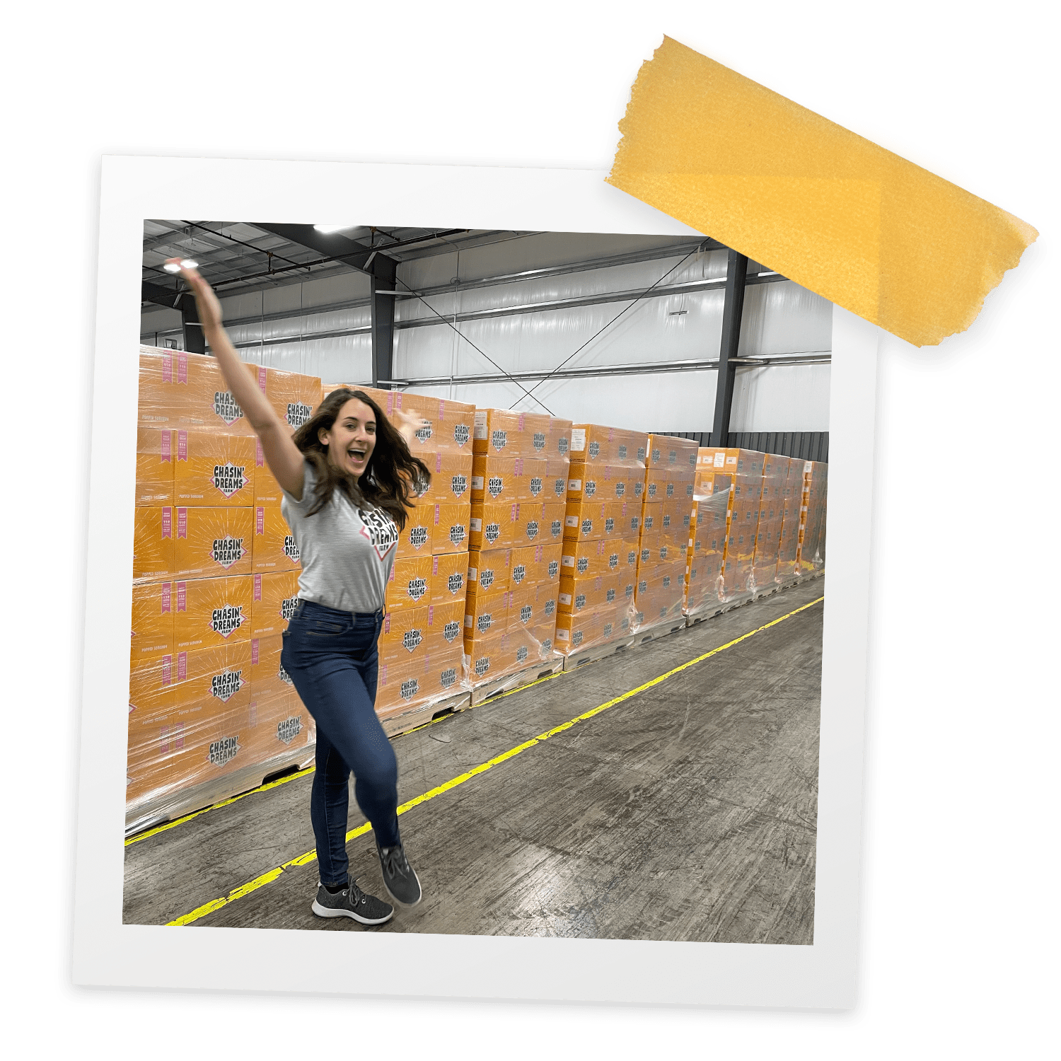 A woman twirls in front of a wall of orange boxes.