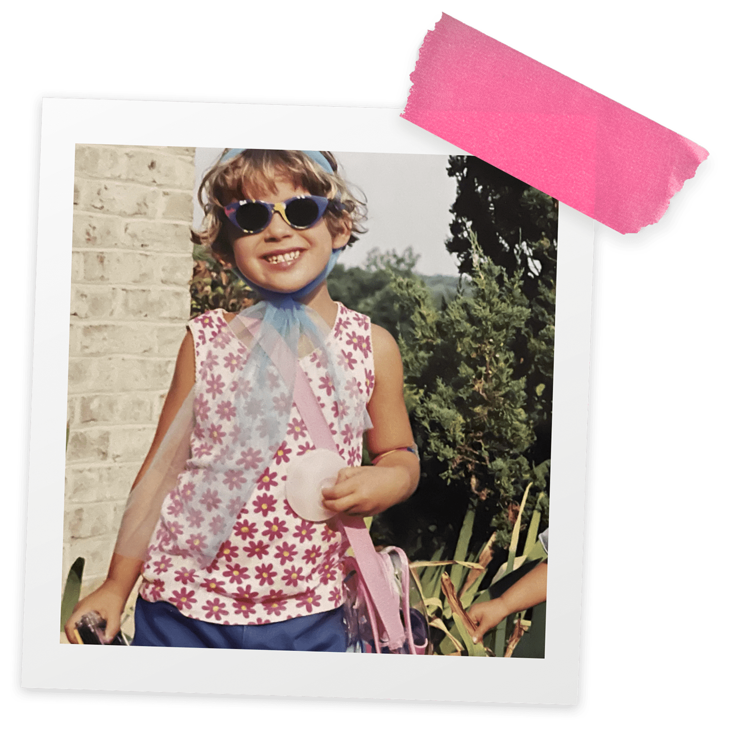 A young girl wearing sunglasses and holding a pink purse.